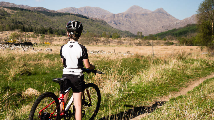 Child and bike with mountains behind